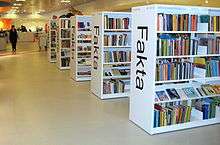 "Library shelves with the word 'Fakta' written on them"