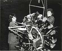 Two Marine Corps women repairing an airplane engine