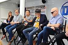 The panel seated in director's chairs