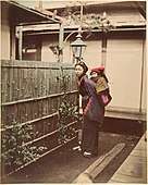 Japanese Woman in Traditional Dress Posing with a Child on her Back, ca. 1870s.