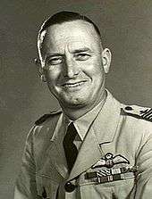 Head-and-shoulders portrait of man in military uniform with pilot's wings on left breast pocket