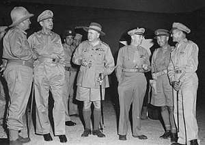 Six men wearing a variety of different uniforms.