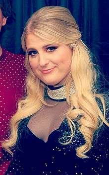 Meghan Trainor is looking into the camera.