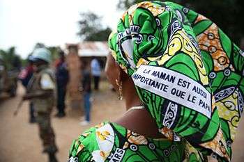 A Congolese woman defends and promotes the rights of women via a message printed on the fabric she wears, 2015.