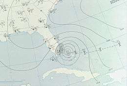 A weather map depicting the letter L, which signifies the center of a storm, and several surrounding circles which signify isobars. Florida is visible in the map.