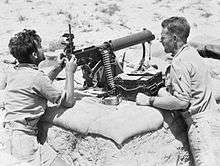 Soldiers man a machine gun in the desert