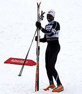 Colour photograph of Philip Boit holding skis