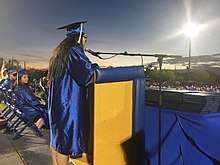 Student speaks to audience at graduation ceremony.
