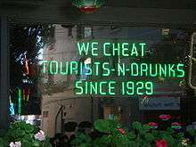 A neon sign reading ""We cheat tourists-n-drunks since 1929"