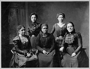 Black and white photograph of five women seated together