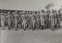 Soldiers standing with rifles on parade