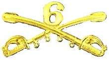 A computer-generated reproduction of the insignia of the Union Army 6th Regiment cavalry branch. The insignia is displayed in gold and consists of two sheathed swords crossing over each other at a 45-degree angle pointing upwards with a Roman numeral 6