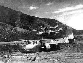 Three twin-engined military aircraft flying low over a valley