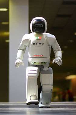 A white-bodied robot with a black face plate walks.