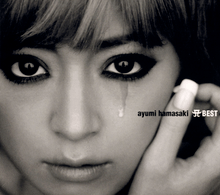 A dark, black-and-white up-close shot of Ayumi Hamasaki looking into the camera, with a teardrop trickling down one cheek.