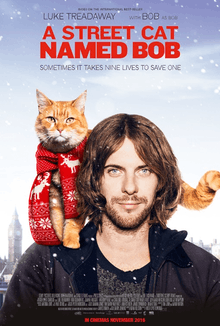 A young man with a beard and shoulder length curly hair stands with a ginger cat sitting on his shoulder wearing a Christmas scarf. Above them is the title "A Street Cat named Bob" and below that the tagline "Sometimes it takes nine lives to save one". Snow falls around them.