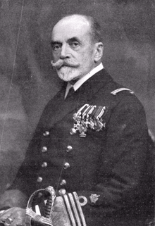 A naval commander in full-dress uniform, wearing several medals on his left breast.