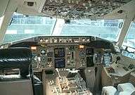 A cockpit of the 767-300ER, which exhibits a hybrid adoption of a new-generation instrument panel and analog gauges and indicators