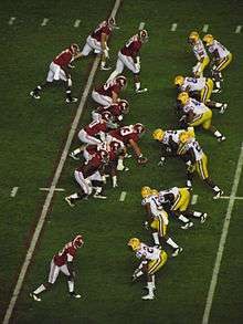 American football players prior to running a play.