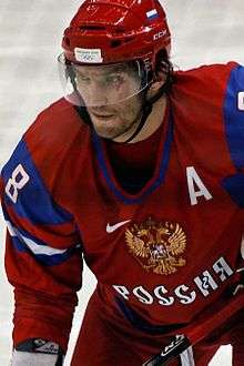 Alexander Ovechkin shown from the waist up during a game. He is wearing a red jersey with a red helmet.
