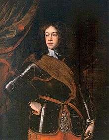 Formal portrait of Mary's father as a young man. He has long bushy hair and a fleshy face, and wears a black suit of armor with a brown shoulder sash.