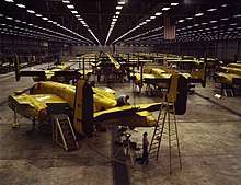 Interior of huge aircraft factory where rows of bombers are being assembled