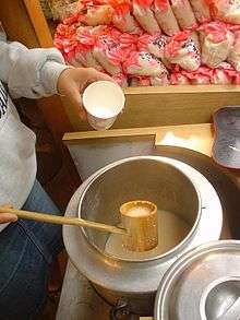 A man with a ladle pouring rice milk