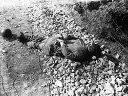 A soldier's body lying on the ground with his hands tied behind his back. Picture taken July 10, 1950.