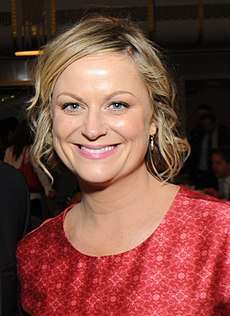 Amy Poehler smiles broadly at the camera.