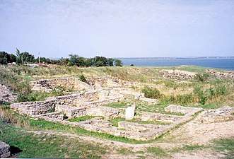 Remains of walls of small structures are seen in the foreground, while the Southern Bug estuary is seen in the background.
