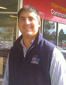 Andrew Wall dressed in a blue vest and striped long-sleeved shirt at Wanniassa Shops