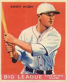 A baseball card image of a man in a white baseball uniform with red trim and white baseball cap with a black brim holding a baseball bat over his right shoulder