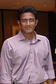 A man in a mauve shirt, wearing glasses, and looking at the camera.