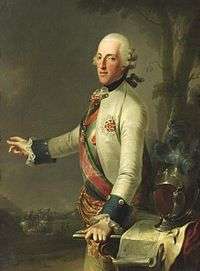 Painting shows a man in an 18th-century white wig, gesturing at a distant battle with his right hand while his left hand rests on a map table. He wears a white military coat with dark blue cuffs and a sash across his right shoulder.