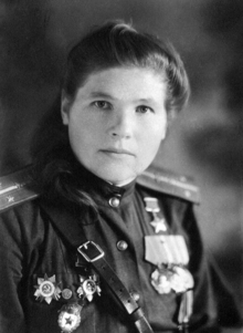 Portait photograph of Antonina Khudyakova in uniform wearing her Hero of the Soviet Union medal, Two Orders of the Red Banner, Two Orders of the Patriotic War, Guards pin, and campaign medals