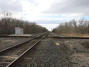 Photo shows two single-track railroads crossing at a 90-degree angle.