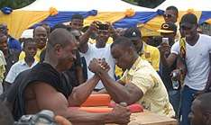 Two alumni engage in an arm wrestling contest