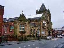 The facade of Ashton town library, constructed from stone and built in Gothic revival style
