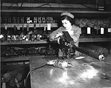 A woman Marine Corps private works on a machine gun during the Second World War