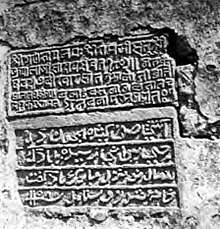 stone carving of text on wall, with 5 lines of Sanskrit then 4 lines of Persian looking like Arabic script