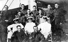 A group portrait of ten soldiers and three sailors on board a ship.