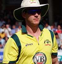 A man in yellow-jersey wearing glasses and a white hat.