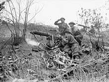Soldiers firing a medium machine from the slope of a hill