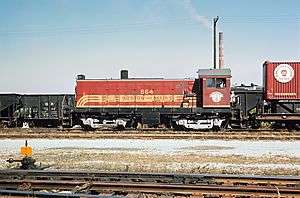 A red locomotive in a freight yard