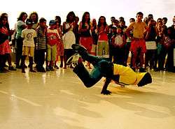 A b-boy performing in Turkey surrounded by a group of spectators.