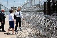 Obama pointing to barbed wire