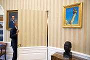 Barack Obama framed by a bust of Martin Luther King Jr. and a painting of Abraham Lincoln