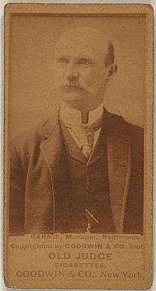 Baseball card showing a bald, white man with a mustache in a medium shot.  The man is wearing a suit and tie.  The first line of the caption beneath the photo says "BARNIE, Manager, Baltimore".  Beneath that the caption says "OLD JUDGE CIGARETTES" and "GOODWIN & CO., New York".