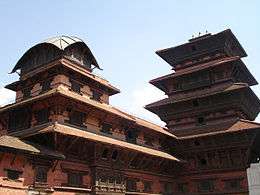 Red-colored multi-storied building and tower like structure.