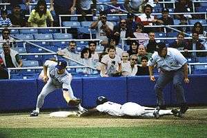 Rickey Henderson successfully steals third base as Jim Presley prepares to catch the ball.
